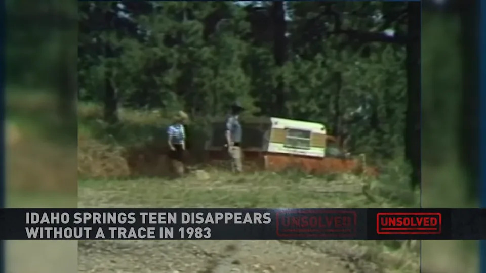 Investigators looking at a red pickup truck