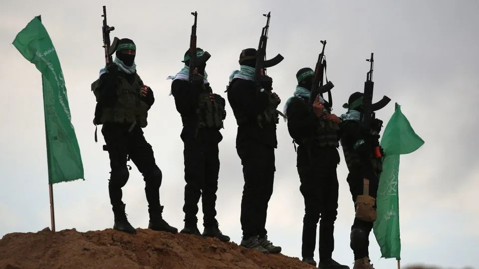 Palestinian Hamas militants gather at the site of the handing over of the bodies of four Israeli hostages in Khan Younis in the southern Gaza on February 20, 2025. - Eyad Baba/AFP via Getty Images