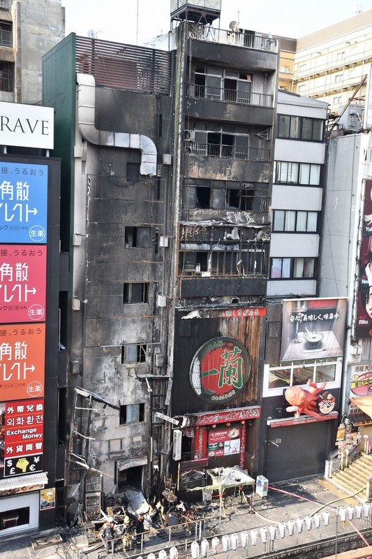 火災があった6階建て（中央左）と7階建て（同右）の2棟のビル。壁面が大きく焼け焦げている＝大阪市中央区で2025年8月18日午後4時44分、川地隆史撮影