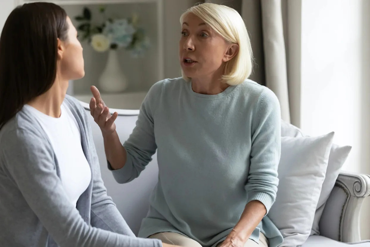 An angry mother and daughter arguing on a couch