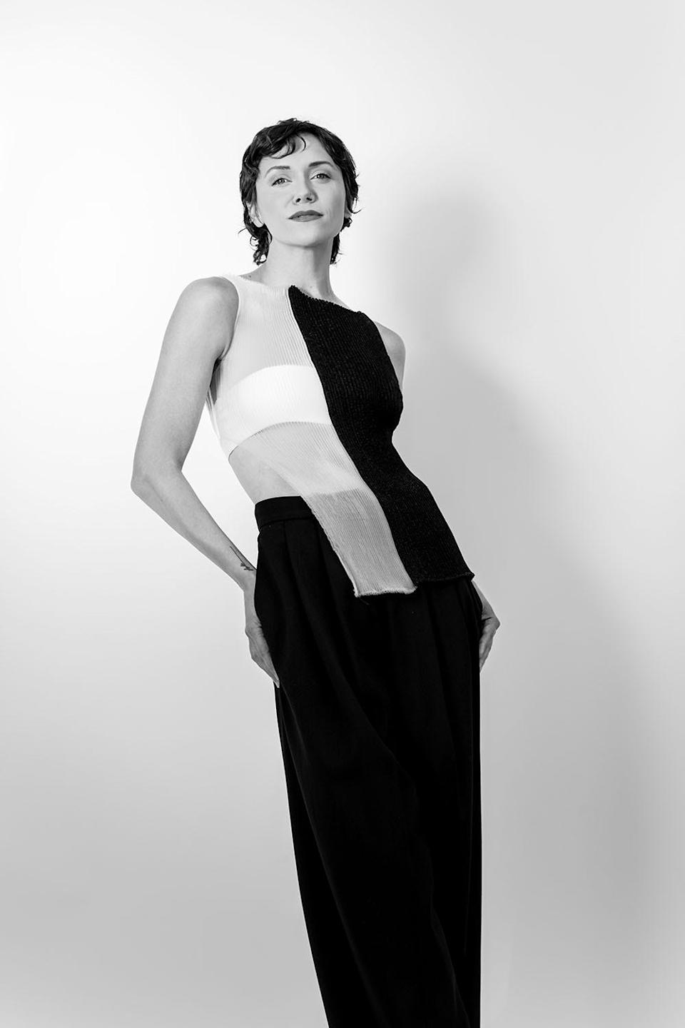 Alyson Stoner con un vestido escotado en blanco y negro posando como una modelo de alta costura.