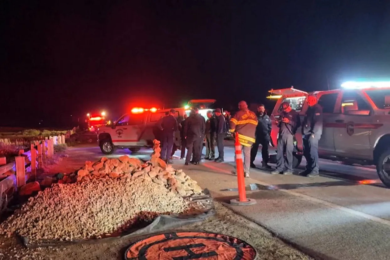 An emergency crew stands outside on a road at night near emergency vehicles (KSBW)