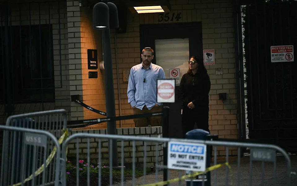 Security guards stand outside a brick building