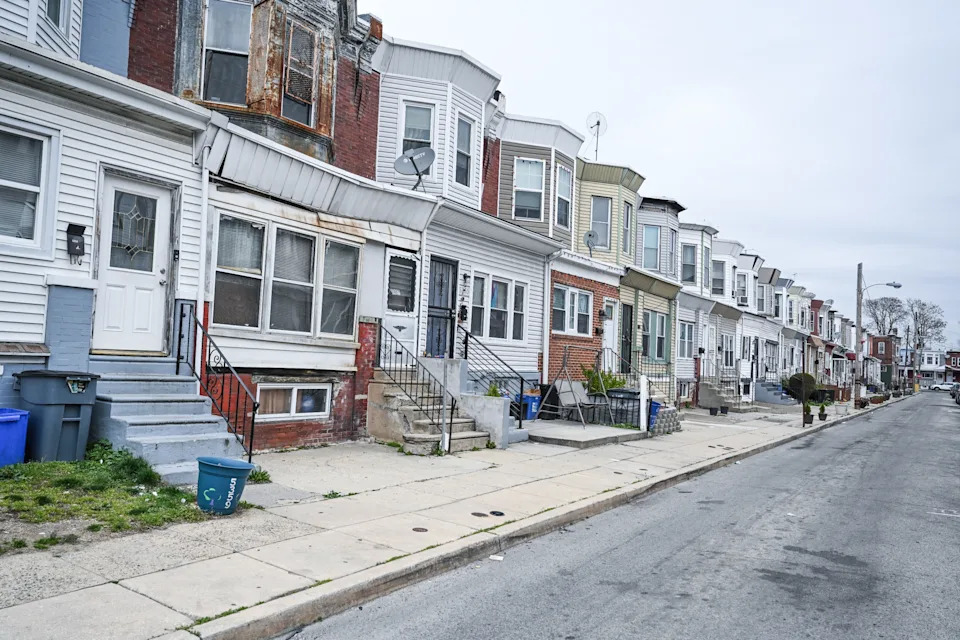 Row of urban homes with small front steps and porches on a quiet street