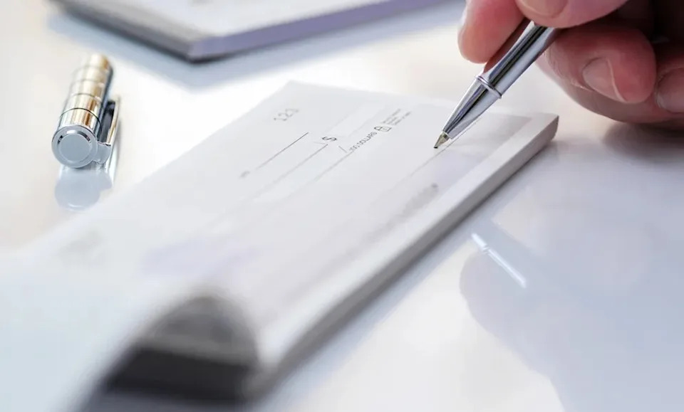 Man signing a check.