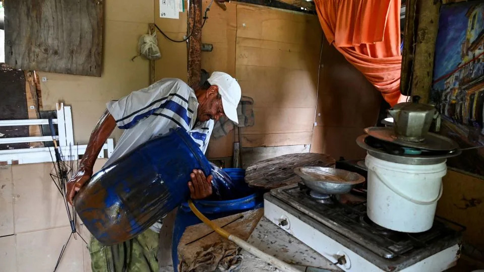 A man pours water into a plastic drum for use at home in Havana in September 2024. - Yamil Lage/AFP via Getty Images