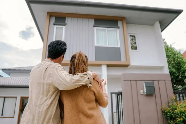 Getty Stock image of a couple standing outside their new house.