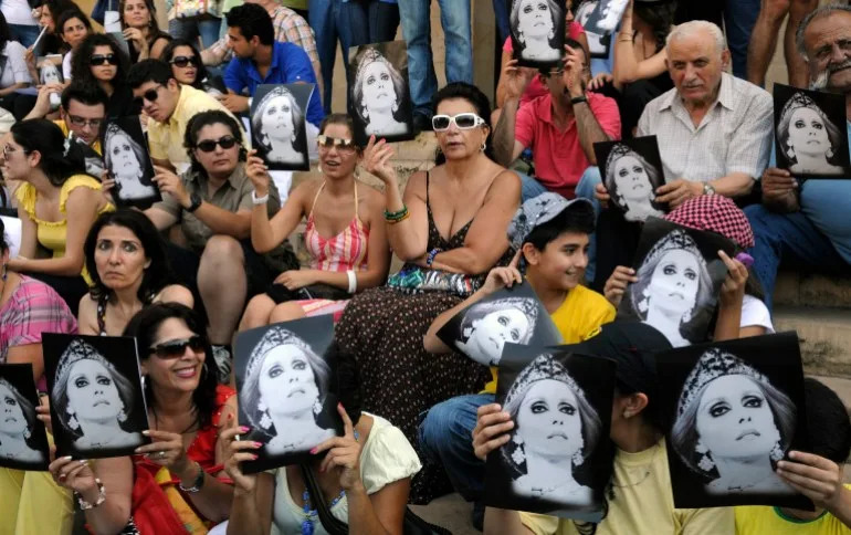 In this photo taken Monday, July 26, 2010, fans of Lebanese diva Fairouz hold her pictures as they protest against a ban preventing her from performing songs composed by 