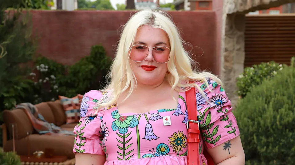 Blonde woman wearing pink sunglasses and a pink dress 