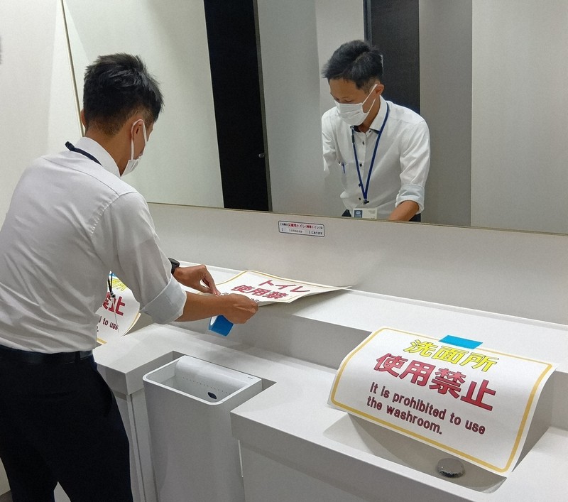 排水管の損傷有無を確認するまで水を流さないため、使用禁止の紙を貼り付ける徳島県職員＝徳島市万代町1の県庁で2025年8月7日午後1時4分、植松晃一撮影