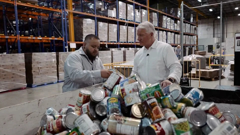 Claudio Rodriguez, vice president for policy and advocacy at the Community Food Bank of Southern Arizona, sorts donated cans with CNN's John King. - CNN