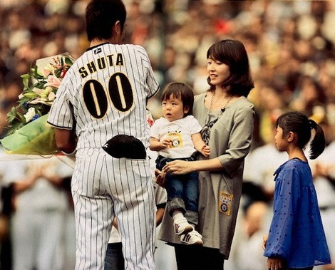 阪神の選手だった父秀太さん（左端）の引退セレモニーで、母睦子さんに抱っこされる沖縄尚学の田中彪斗選手＝家族提供