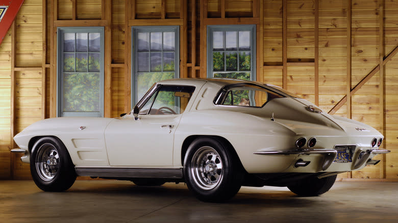 A white 1963 Chevrolet Corvette from the rear parked in a garage.