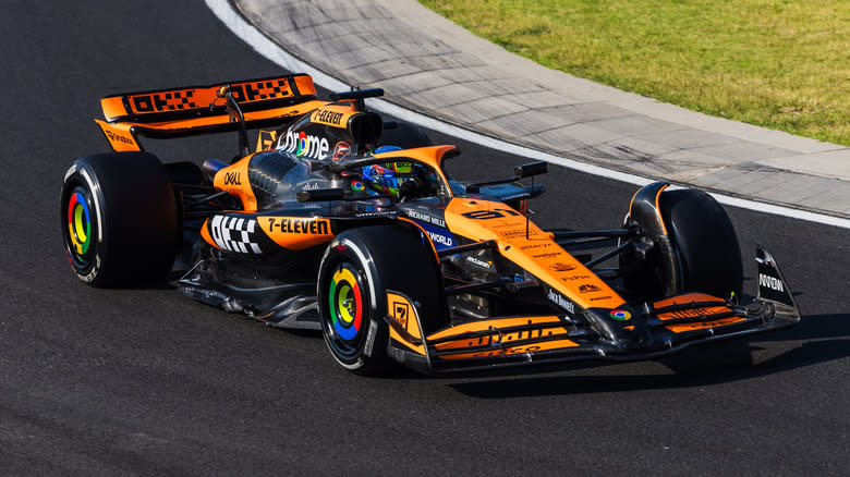 Austria's Oscar Piastri driving orange McLaren Formula 1 car around track