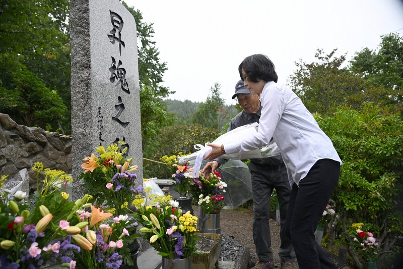 御巣鷹の尾根に建つ「昇魂之碑」に献花するJALの鳥取三津子社長（右）＝群馬県上野村で2025年8月12日午前11時57分（代表撮影）