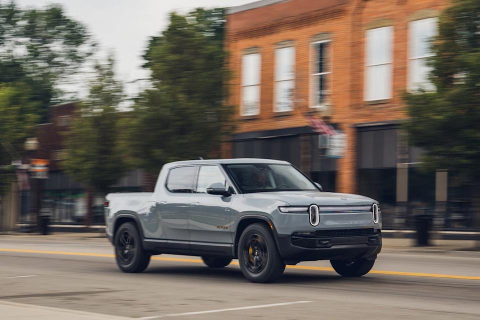 front three quarter view of silver pickup truck in motion on urban road with blurred background.