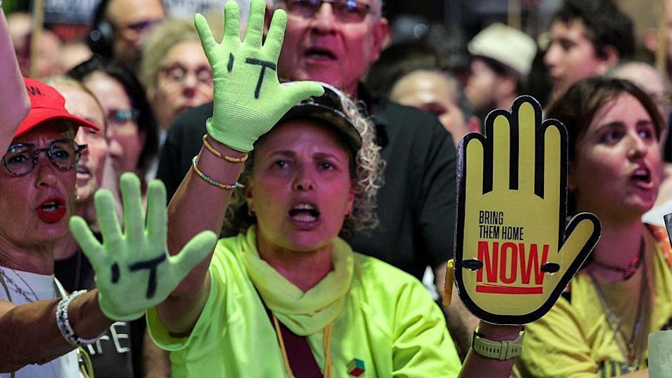 Manifestantes con un cartel que dice: