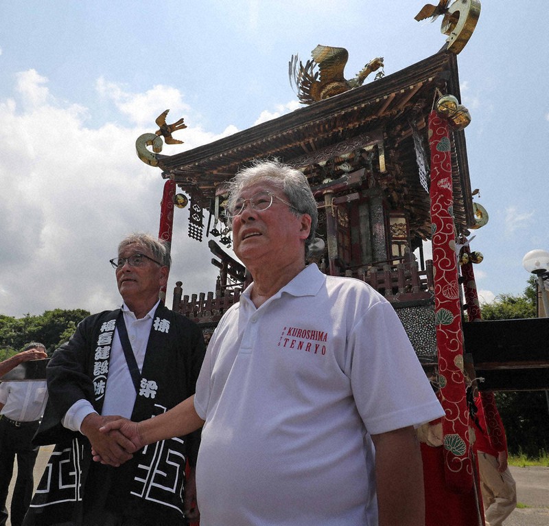 みこしを前に固い握手を交わす福田喜次さん（左）と氏子総代長の林賢一さん＝石川県輪島市で2025年7月31日午前11時7分、岩本一希撮影