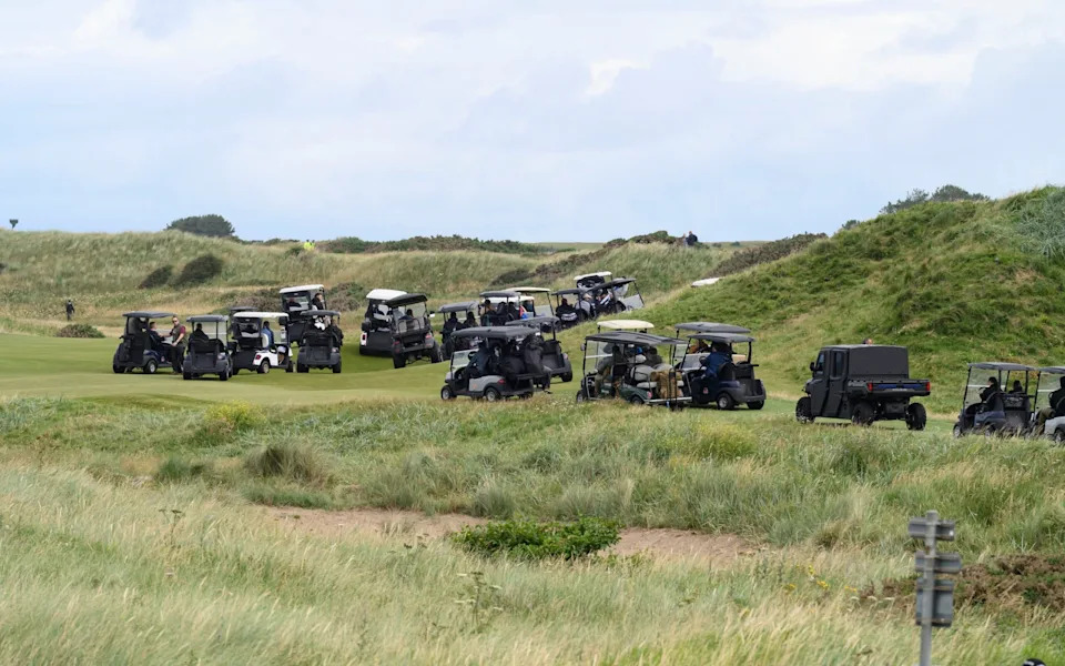 The US president's cavalcade makes its way across the course