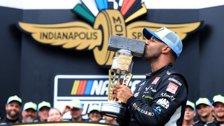 Bubba Wallace, driver of the #23 Chumba Casino Toyota, kisses the Brickyard 400 trophy in victory lane after winning the NASCAR Cup Series Brickyard 400 Presented by PPG at Indianapolis Motor Speedway on July 27, 2025 in Indianapolis, Indiana.