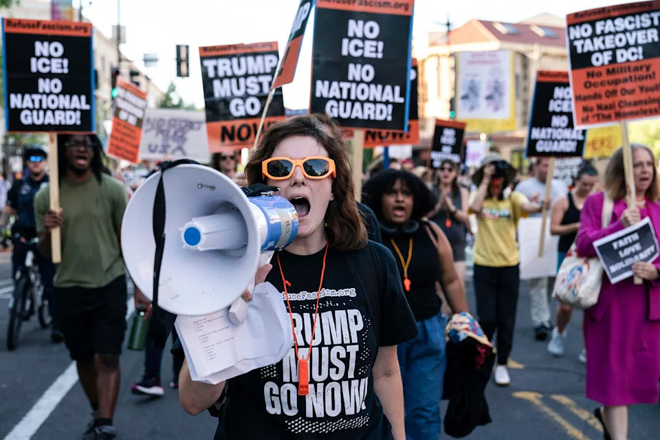 People protest on the street holding signs against Trump and ICE (Jose Luis Magana / AP)