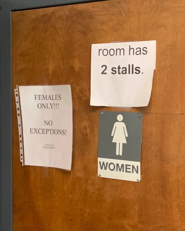 Three signs on a door: "Females only! No exceptions!", "Room has 2 stalls.", and a women's restroom symbol