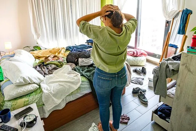 Getty Woman in front of messy room (stock image)