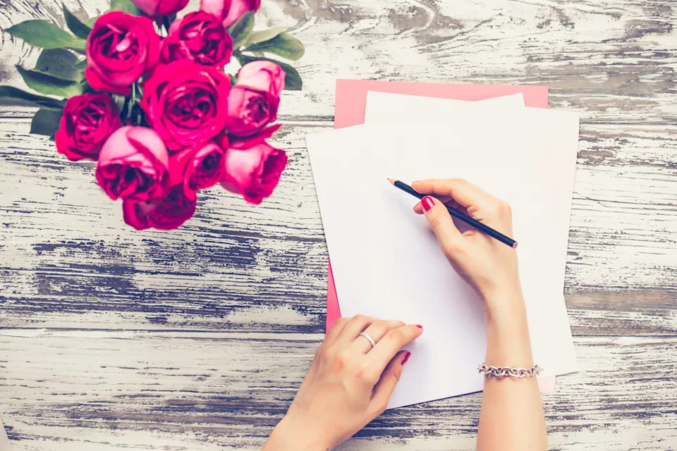 Woman writing on a blank piece of paper.