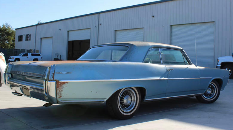 1964 Pontiac Catalina parked in a parking lot in front of storage units