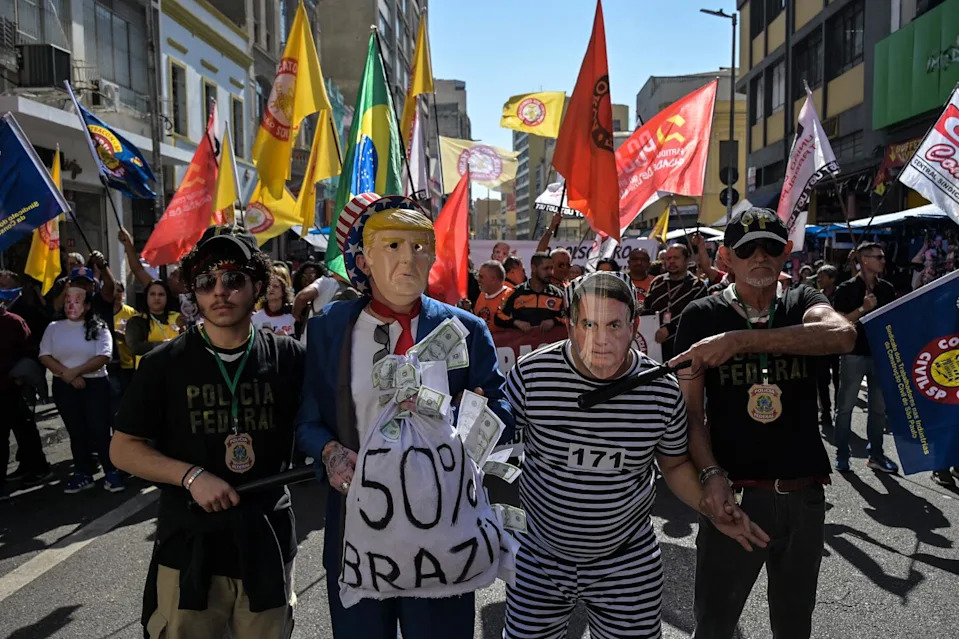 Protesters wearing masks depicting President Donald Trump and President Jair Bolsonaro take part in a protest