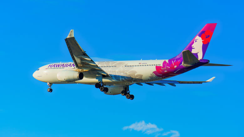 Hawaiian Airlines Airbus A330 approaching for landing with a vibrant blue sky backdrop.