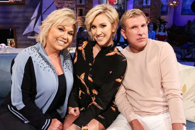 Vivian Zink/NBC/NBCU Photo Bank via Getty  Savannah Chrisley (center) between mom Julie Chrisley and dad Todd Chrisley on 'Hollywood Game Night'