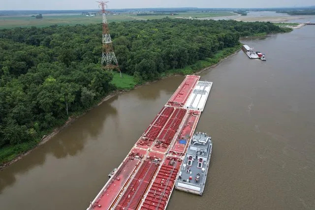 Jeff Roberson/AP A blue tarp covers the wreckage of a helicopter crash onto a barge Thursday, Aug. 7, 2025