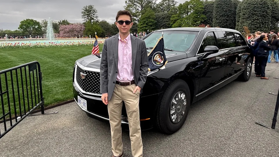Eric Tarpinian-Jachym stands in front of a car