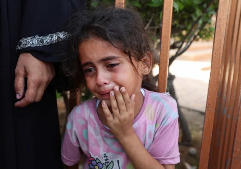 A child reacts during the funeral of Palestinians killed in an overnight Israeli strike, according to medics, at Nasser hospital, in Khan Younis in the southern Gaza Strip, July 28, 2025. REUTERS/Ramadan Abed