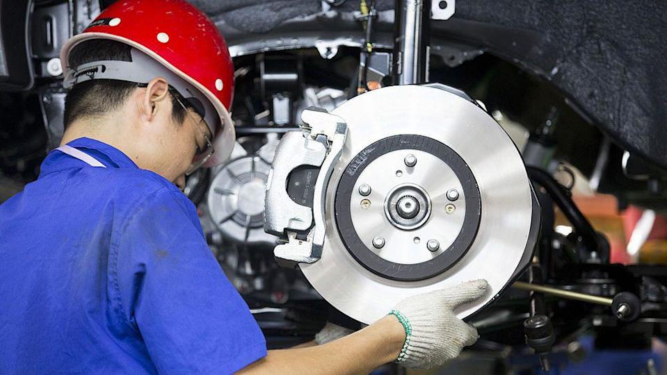 An employee installs brake pads on new Chinese SUV in a BYD assembly plant in Shenzhen.