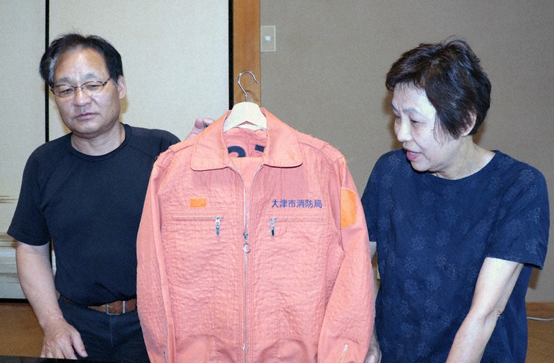 救助係のオレンジの制服を誇りにしていた青木裕樹さんの思い出を語る父親の勝彦さん(写真左)と母由美さん=大津市内で、岸桂子撮影