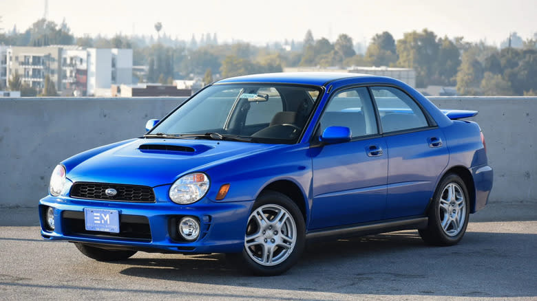a blue Bugeye WRX parked on the top level of a parking structure