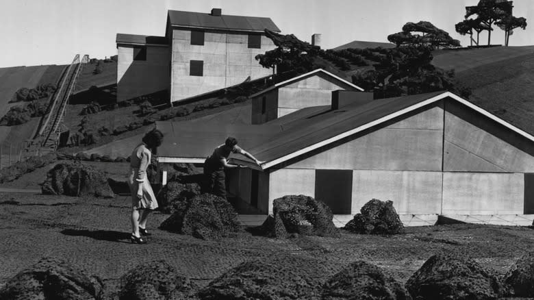 Two people on the roof of the camouflaged Boeing Plant 2, showing the height of the faked houses.