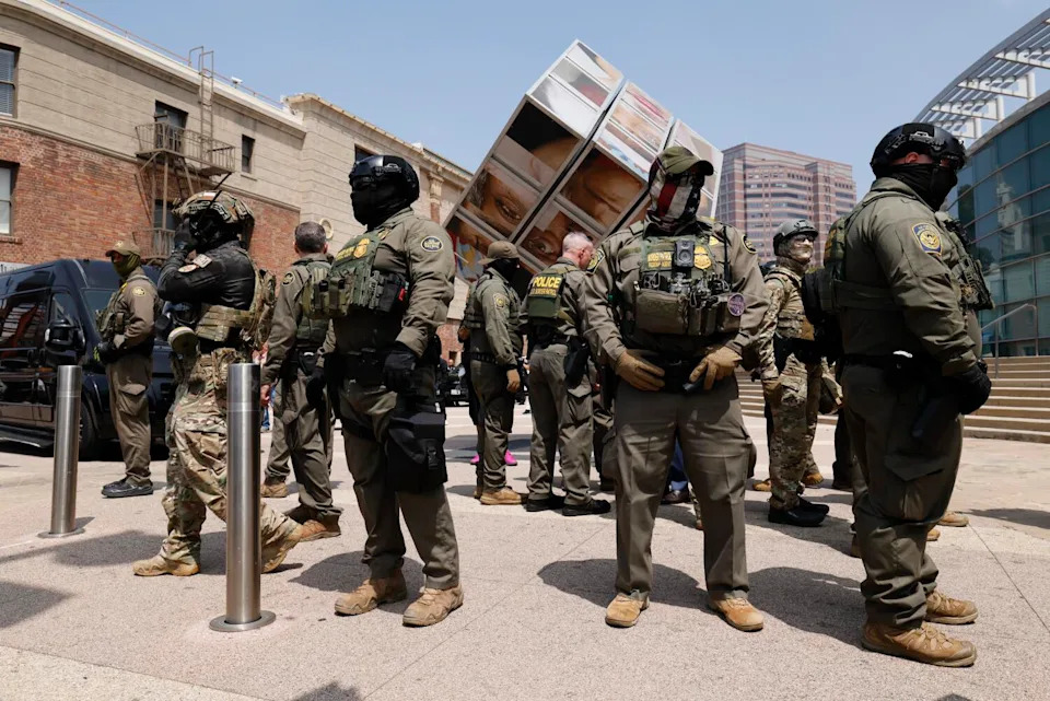 People in military uniforms stand outdoors.
