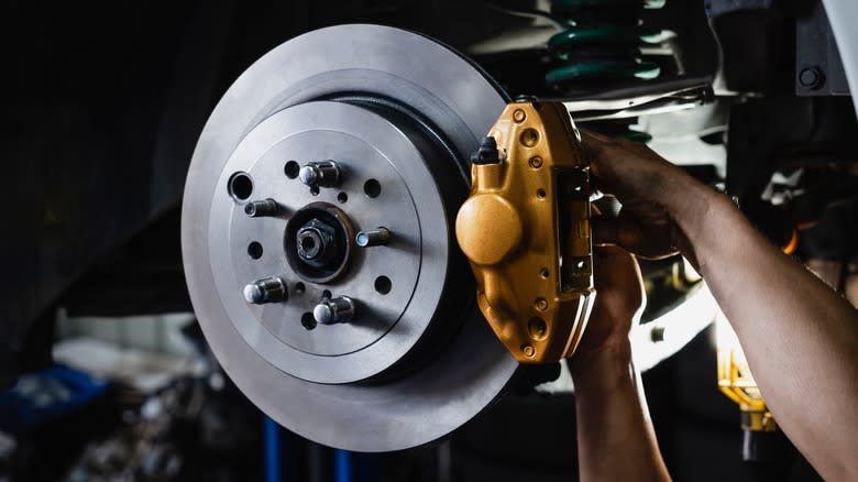 A tight shot of a mechanic working on a modern disc brake setup.