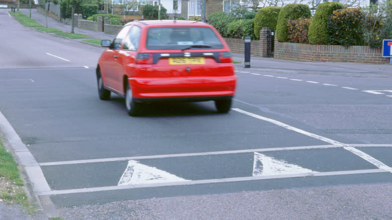 A speed hump in Europe and a red car