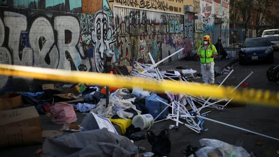 A worker stands on a corner during a street cleaning operation in Skid Row Los Angeles, California, U.S., December 9, 2024. - Daniel Cole/Reuters