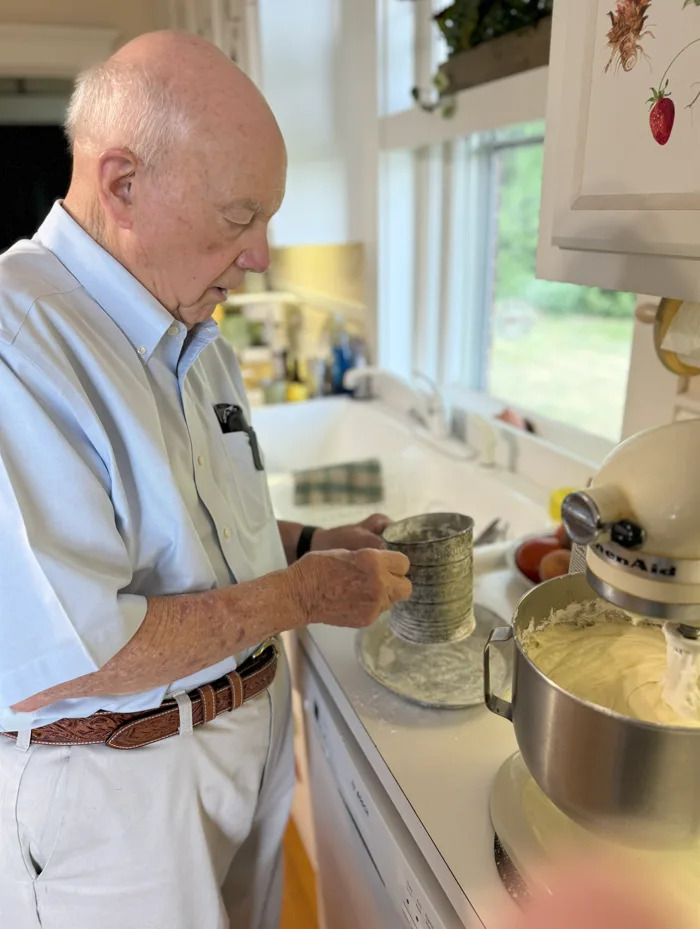 Bob Hall, 95, sifts flour as he make as pound cake to enter in the 2025 Kentucky State Fair culinary competition. Hall has been attending the Kentucky State Fair since World War II, but 2024 was the first time he ever participated in the culinary contest.