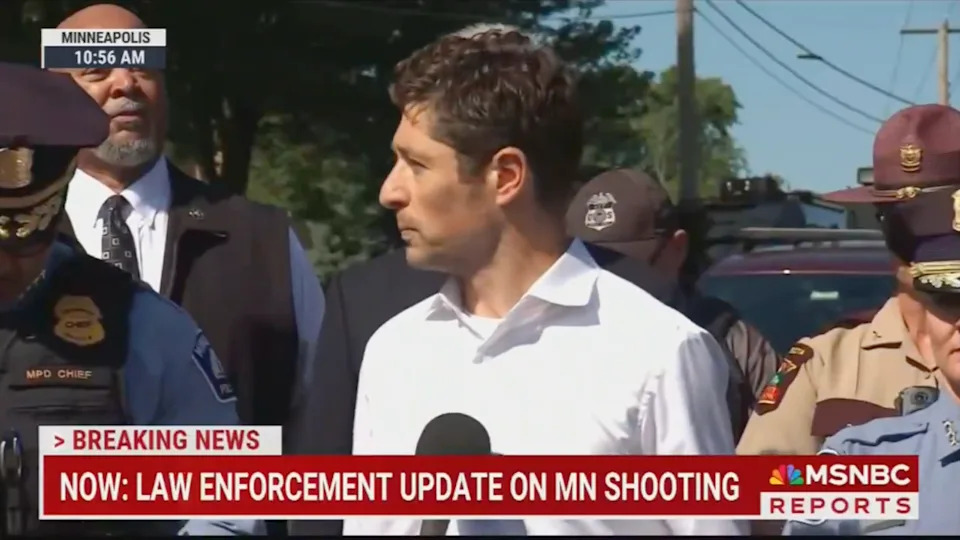 Group of officials, one speaking at a press conference about law enforcement's update on a Minnesota shooting. Text on screen displays "Breaking News."