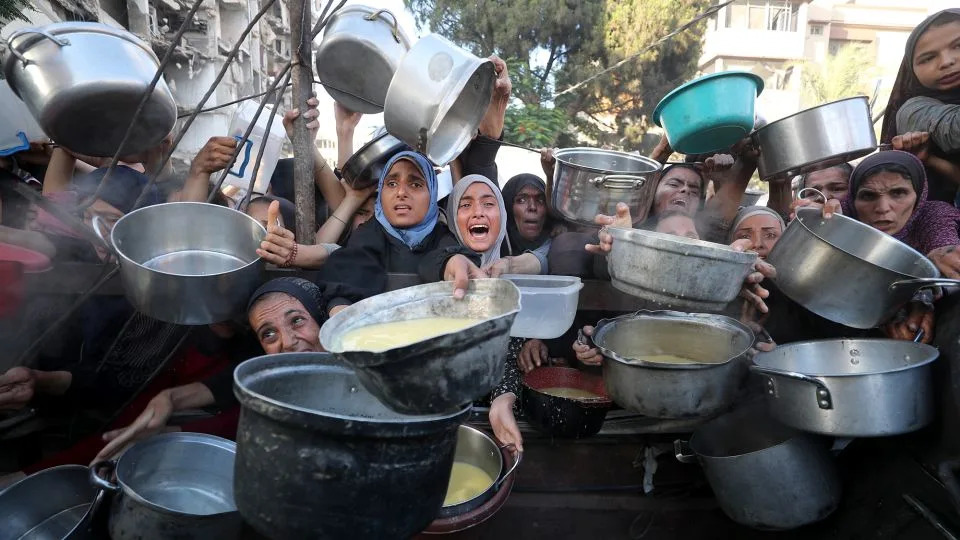 Palestinians, including children struggle to receive hot meals distributed by a local charity in Gaza City on July 14. - Mahmoud ssa/Anadolu/Getty Images
