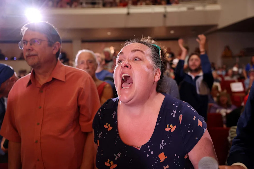 Scott Morgan/Reuters - PHOTO: Sarah Davis of Lincoln, Nebraska, shouts after asking U.S. Representative Mike Flood a question during a town hall in Lincoln, Nebraska, U.S., August 4, 2025.