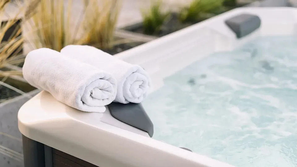white towels placed on the edge of a hot tub with bubbling water