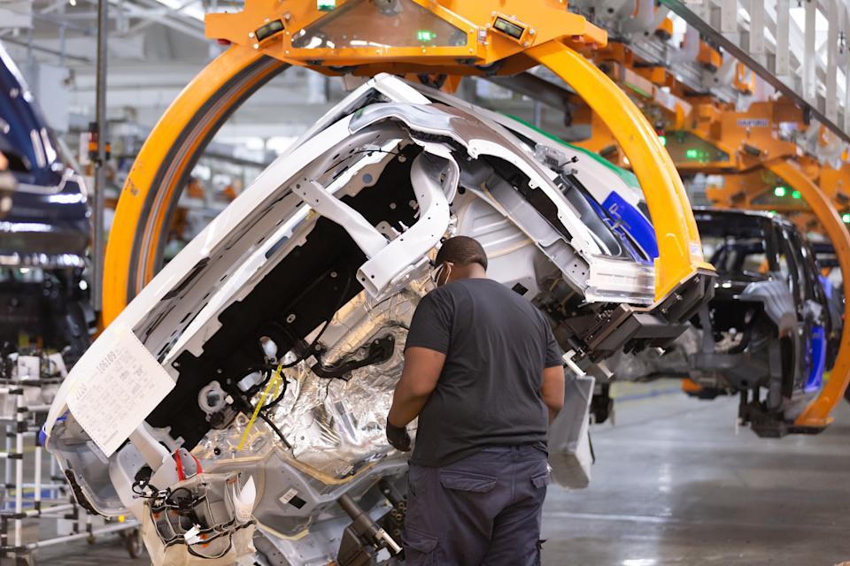 An employee installs parts on the all-new Wagoneer as it rotatesStellantis