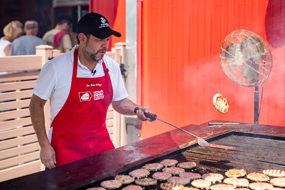 U.S. Sen. Ruben Gallego, D-Arizona, flips a pork burger at the Iowa Pork Producers Association Tent during the the second day of the Iowa State Fair on Aug. 8, 2025, in Des Moines, Iowa.